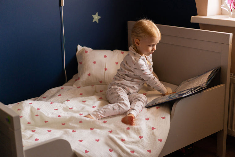 Mädchen im gemütlichen Bett mit Herzchen-Kinderbettwäsche „Love"