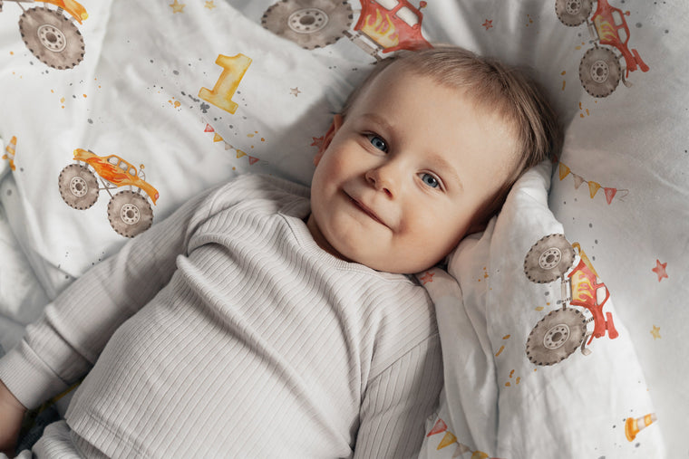 LESLIS Kinderbettwäsche „Monstertrucks" – Junge im Bett mit bezogener Bettdecke