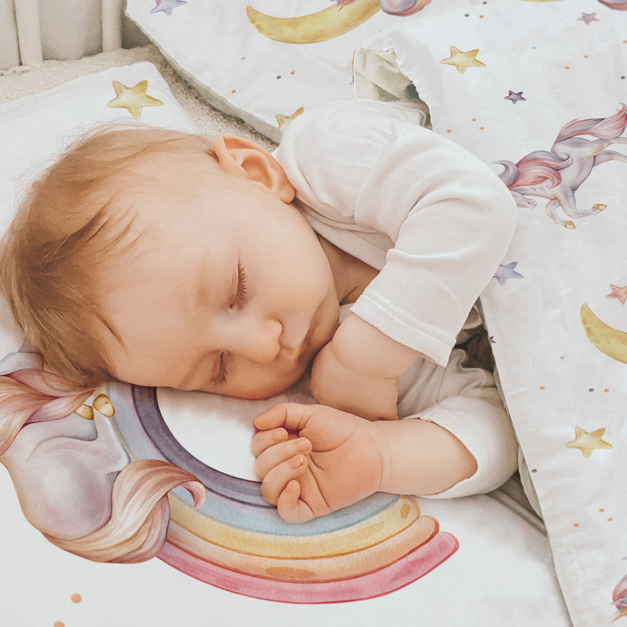 LESLIS Kinderbettwäsche „Regenbogen Einhorn" – Mädchen im Kinderbett mit Einhorn- und Regenbogen-Motiv