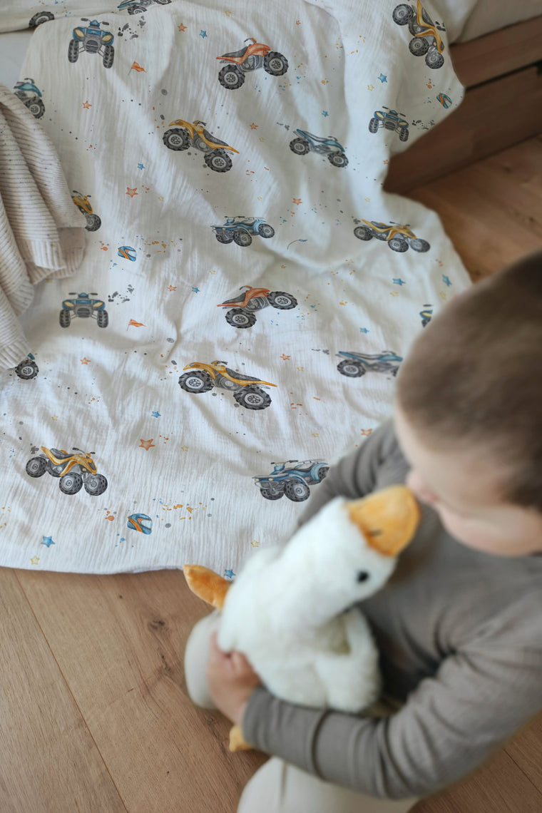 LESLIS Kinderbettwäsche „Quads" – Junge im Bett mit bezogener Bettdecke