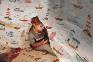 LESLIS Kinderbettwäsche „Am Meer" – Junge im Kinderbett mit maritimem Motiv