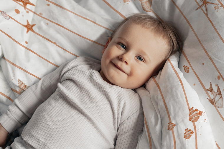 LESLIS Kinderbettwäsche „Kleine Seesterne" – Junge im Bett, Musteransicht der Bettdecke