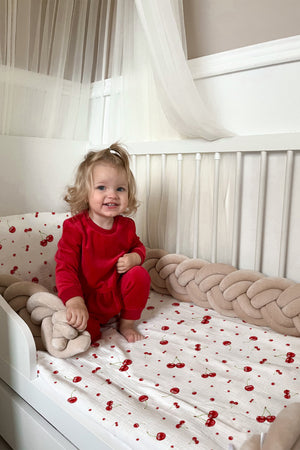 Mädchen im Bett mit Kinderbettwäsche „Kirschen", verspieltes Kirschen-Motiv