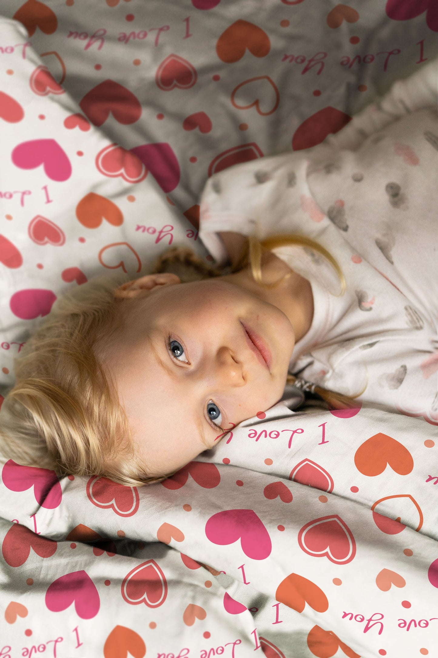 Kinderzimmer-Szene mit Mädchen und Kinderbettwäsche „I love you", Herzen-Motiv auf Baumwolle