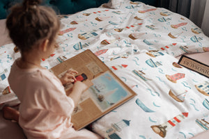 LESLIS Kinderbettwäsche „Am Meer" – Mädchen im Kinderbett, Leuchtturm- und Boot-Motiv