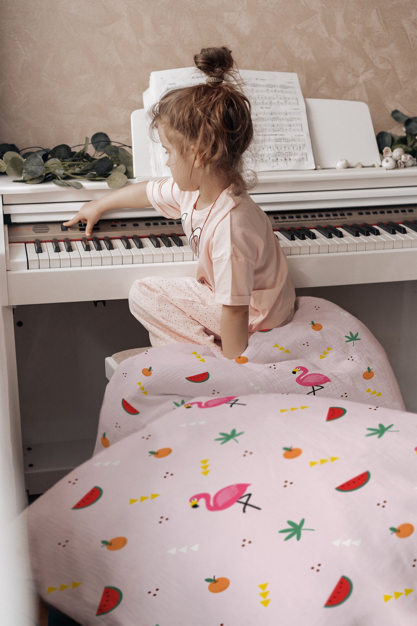 Mädchen lacht im Bett mit Flamingo-Kinderbettwäsche in Rosa