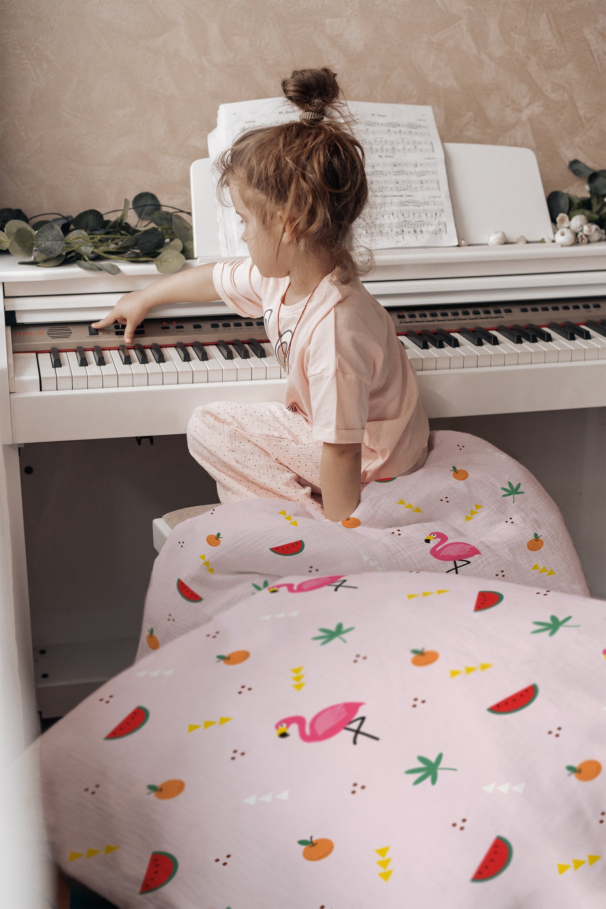 Mädchen lacht im Bett mit Flamingo-Kinderbettwäsche in Rosa