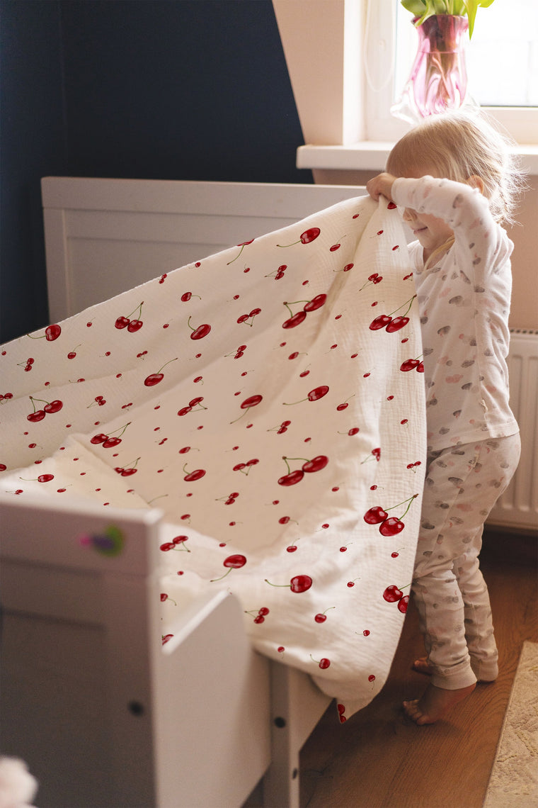 Mädchen entspannt im Bett mit Kirschen-Kinderbettwäsche „Kirschen"