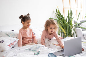 LESLIS Kinderbettwäsche „Dino Galaxy" – Kind im Kinderbett, Dino-Motiv im Detail