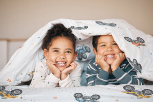 LESLIS Kinderbettwäsche „Quads" – Kind im Bett mit bezogener Bettdecke