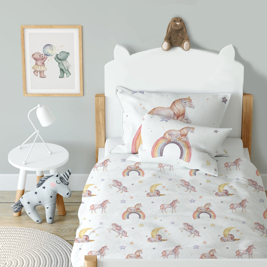 LESLIS Kinderbettwäsche „Regenbogen Einhorn" – bezogenes Kinderbett in einem eingerichteten Kinderzimmer