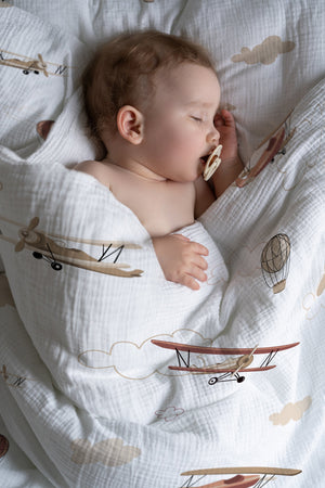 Kind schläft in weicher Kinderbettwäsche „Flugzeuge und Wolken" mit Himmel-Motiv